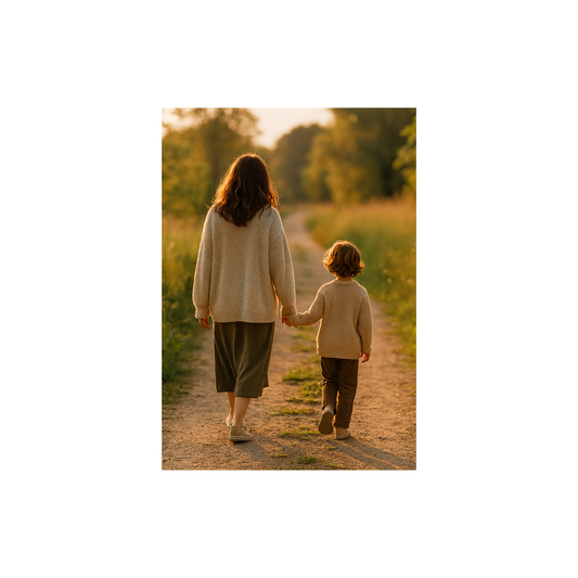 Eine Mutter und ihr Kind gehen Hand in Hand einen naturbelassenen Weg entlang, von hinten gesehen. Umgeben von warmem Licht und grüner Landschaft symbolisiert das Bild Vertrauen, Hochsensibilität und den gemeinsamen Weg in einem eigenen Tempo.