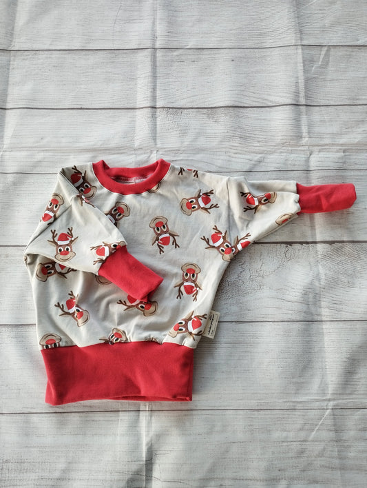 Mitwachsender Kinderpullover mit Rentier-Motiv aus OEKO-TEX zertifiziertem French Terry, handgemacht in Oldenburg, mit roten Bündchen.