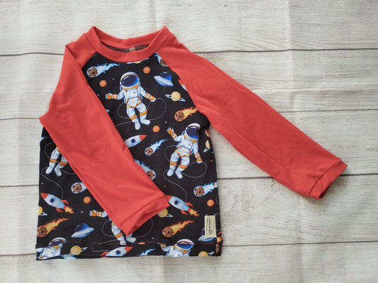 Kinder-Raglanshirt mit Astronauten-Muster auf schwarzem Stoff und roten Ärmeln – handgemacht aus elastischem Baumwolljersey