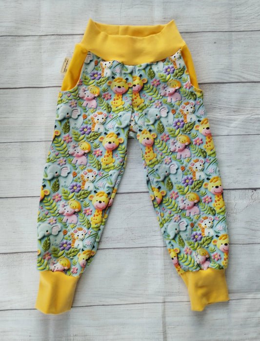 Kinder-Pumphose mit Safari-Muster auf hellblauem Stoff, gelben Bündchen und Taschen – handgemacht aus elastischem Baumwolljersey