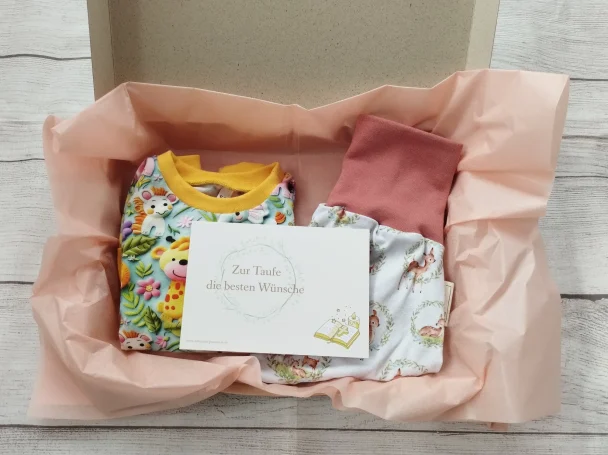 Geschenkbox mit handgemachter Babykleidung im Tierprint, verpackt mit rosa Seidenpapier und Grußkarte  - perfektes Geschenk zur Taufe